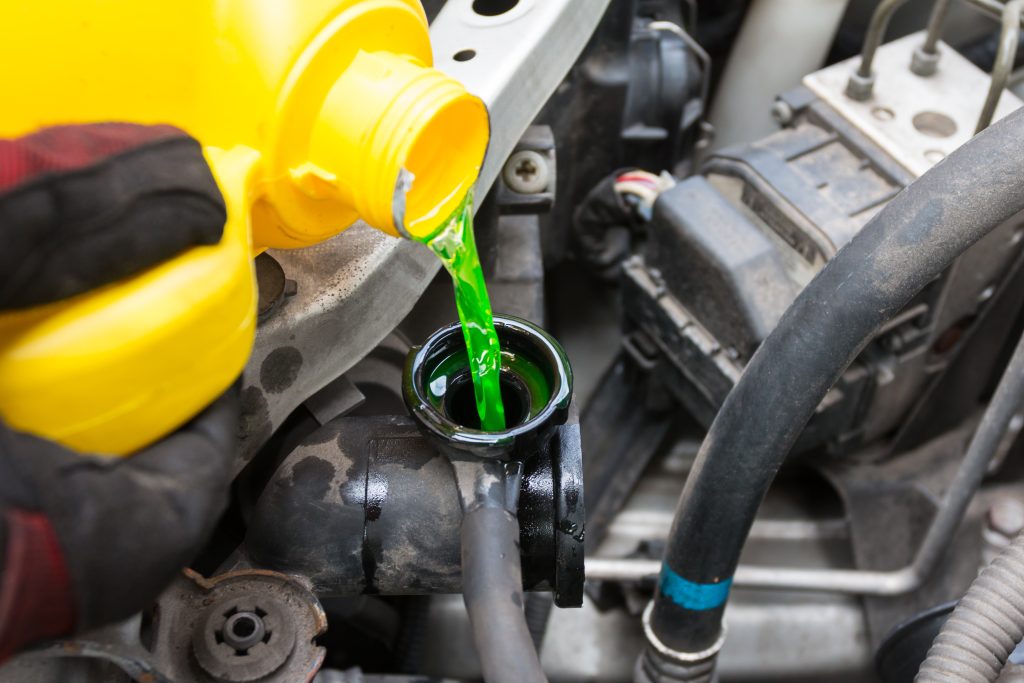 A Everett Buick GMC service worker pouring new coolant in your Buick in Bryant, AR