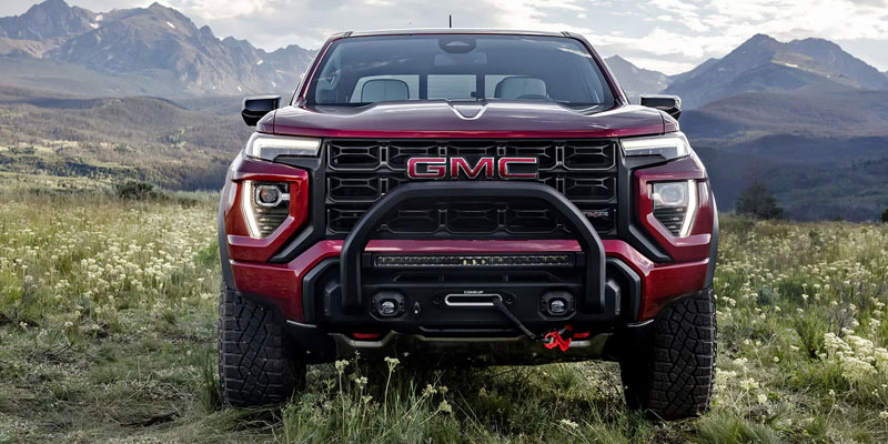 The front grille of the 2026 GMC Canyon in a beautiful field near Bryant, AR 